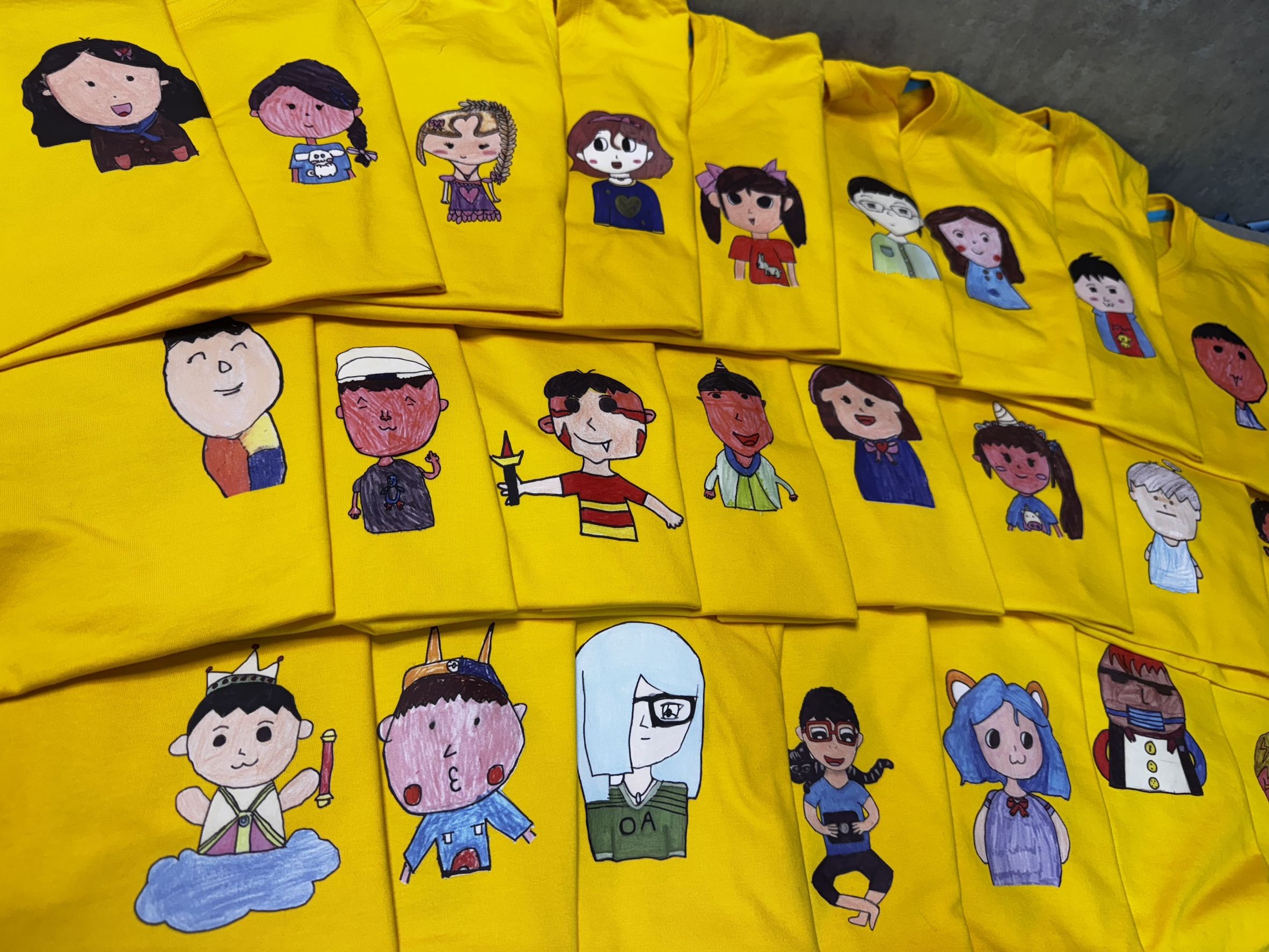 孩子手繪角色印製在黃T上，展現創意與童心