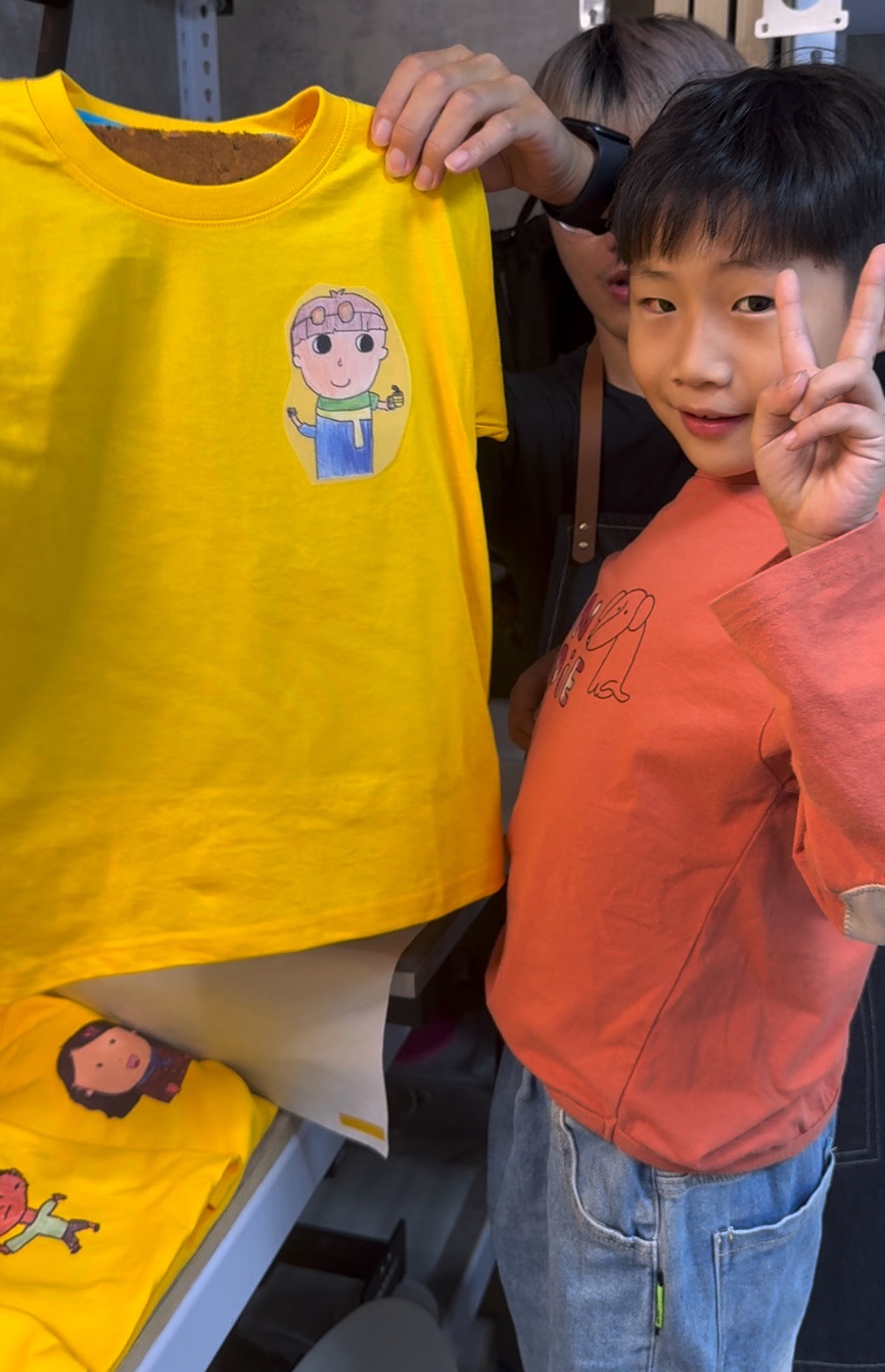 孩子與完成的班服合照，充滿成就與笑容